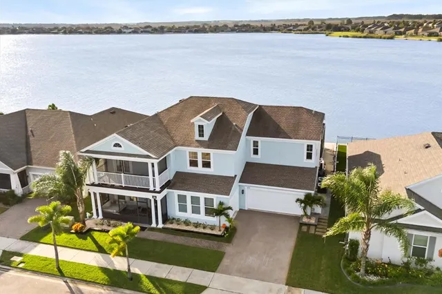 an aerial view of a house with a garden and lake view