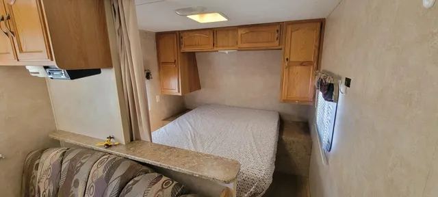 a bedroom with a bed and a refrigerator