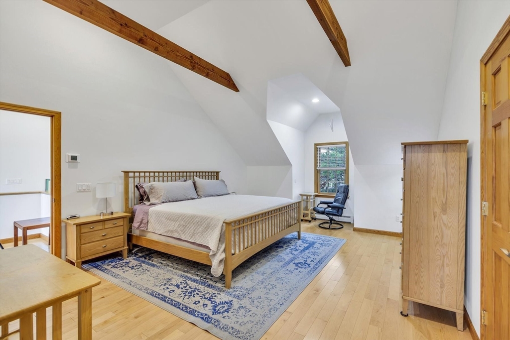 128 Shore Road Truro, MA 02666 - Photo 34 of 42 a spacious bedroom with a bed and wooden floor