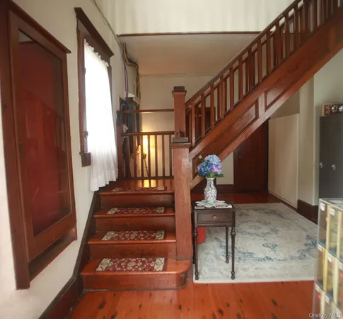 a view of entryway and hall with wooden floor
