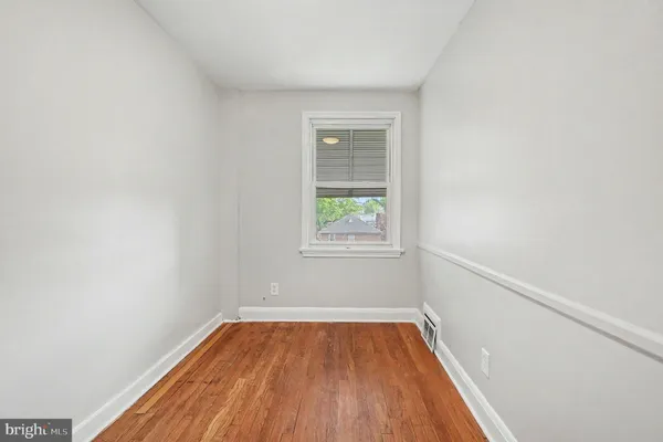 a view of a room with wooden floor and window