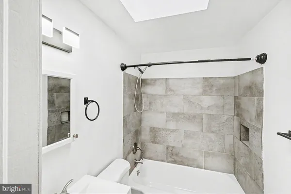 a bathroom with a shower bathtub and mirror