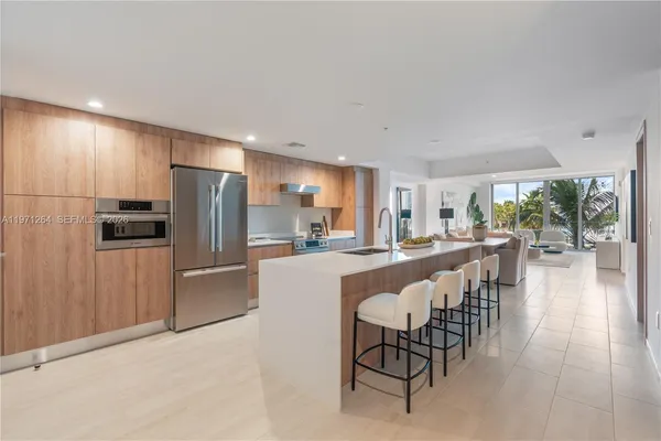 a dining hall with stainless steel appliances a refrigerator and a dining table with wooden floor