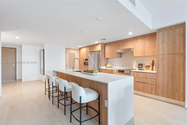 a kitchen with stainless steel appliances a sink stove and cabinets