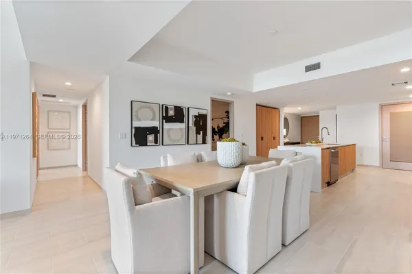 a living room with furniture a flat screen tv and kitchen view