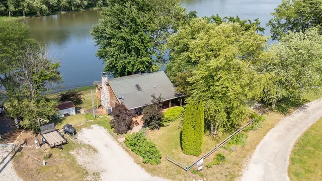 an aerial view of a house with swimming pool and large trees