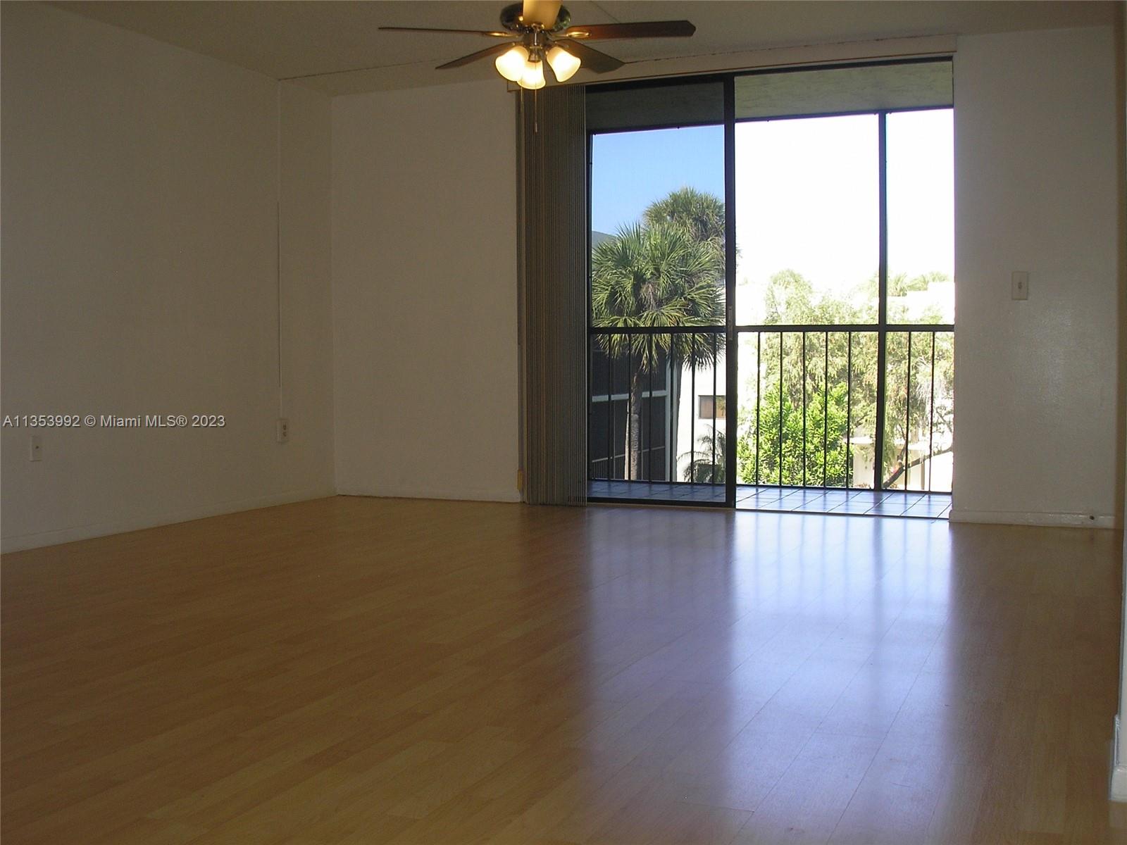 8035 Southwest 107th Avenue, Unit 317 Miami, FL 33173 - Photo 3 of 17 a view of a livingroom with wooden floor and a window