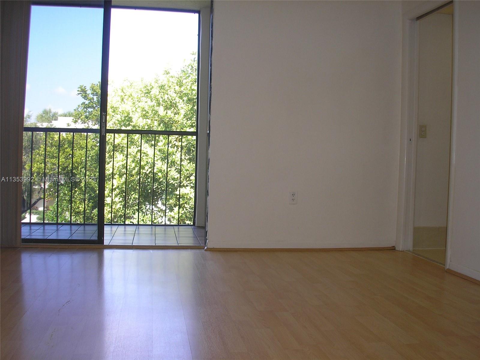 8035 Southwest 107th Avenue, Unit 317 Miami, FL 33173 - Photo 8 of 17 a view of wooden floor and windows in a room