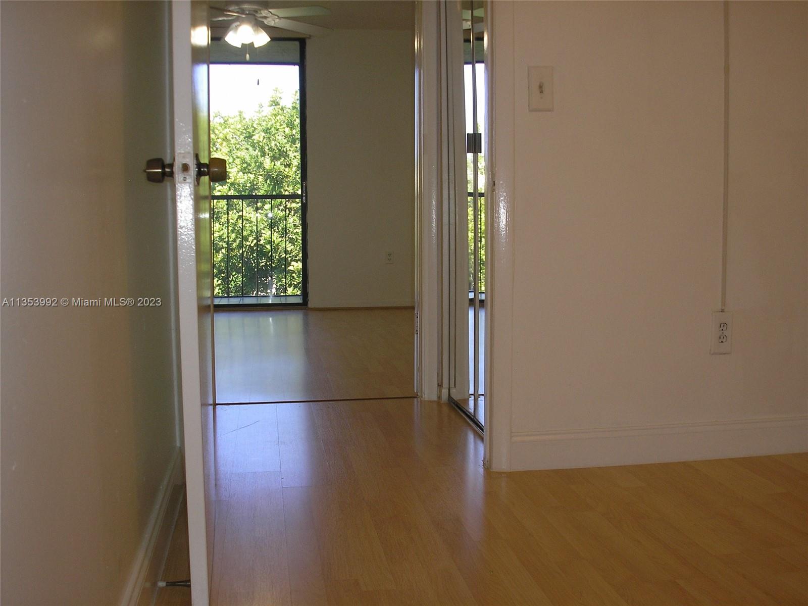 8035 Southwest 107th Avenue, Unit 317 Miami, FL 33173 - Photo 10 of 17 an empty room with wooden floor and windows