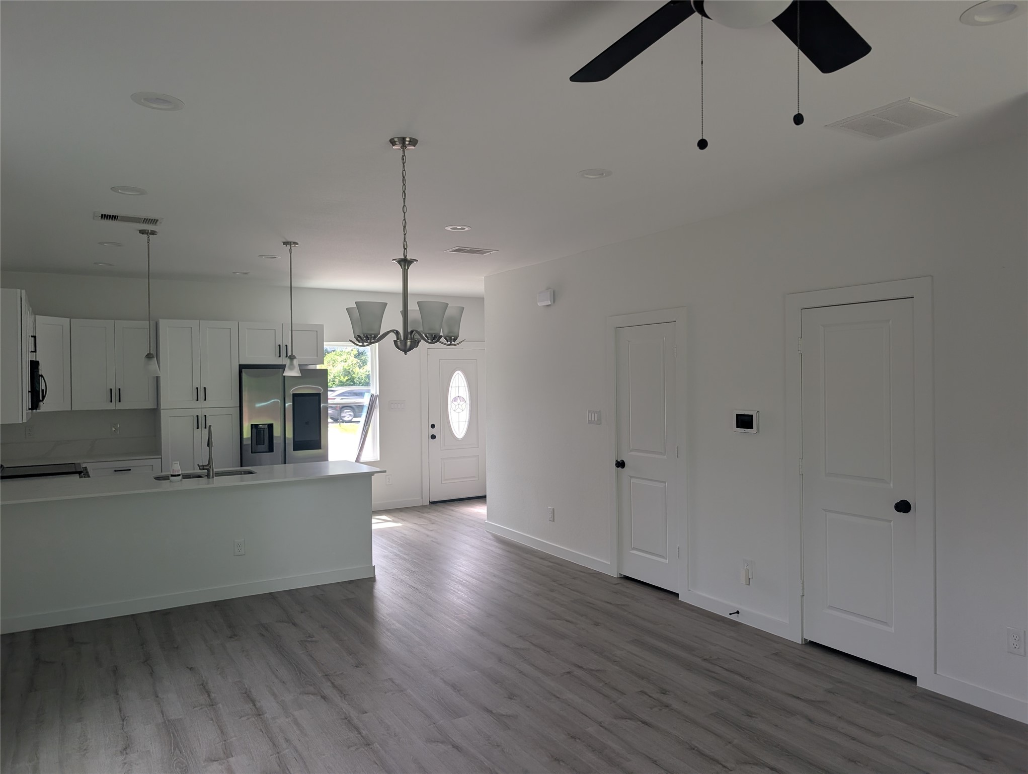 7813 Hirsch Road, Unit B Houston, TX 77016 - Photo 3 of 8 a kitchen with stainless steel appliances granite countertop a refrigerator a oven a sink and white cabinets with wooden floor