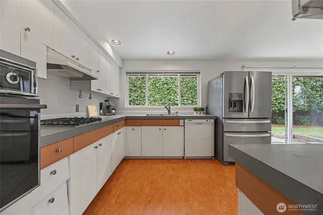 a kitchen with granite countertop a sink stainless steel appliances and cabinets