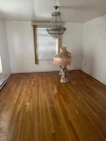 a view of a room with wooden floor and chandelier
