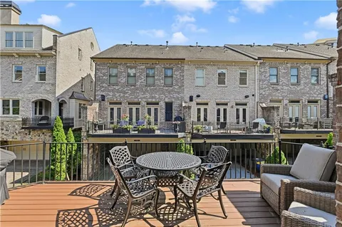 a view of a patio with table and chairs with wooden floor and fence