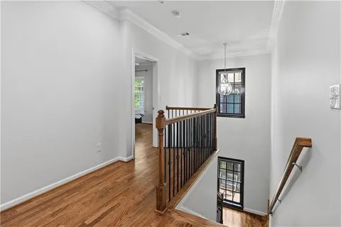 a view of a hallway with wooden floor and stairs