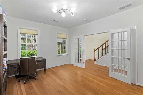 a view of an empty room with a window and wooden floor