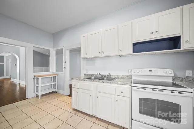 a kitchen with white cabinets and white appliances