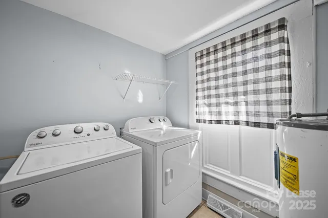 a view of washer and dryer with bathroom in the background