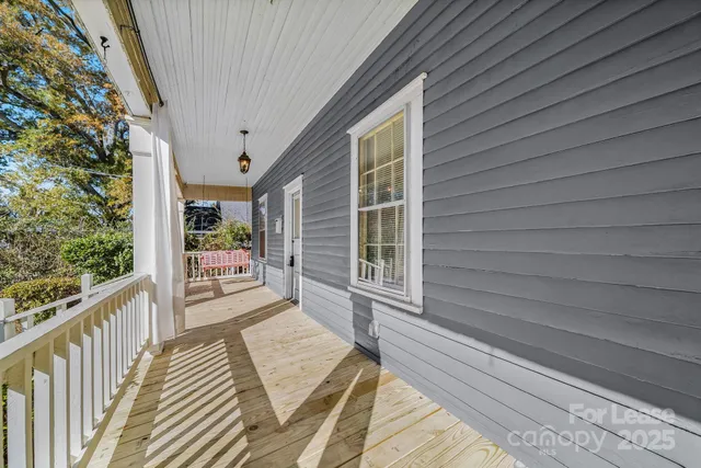a view of a balcony with wooden floor and fence