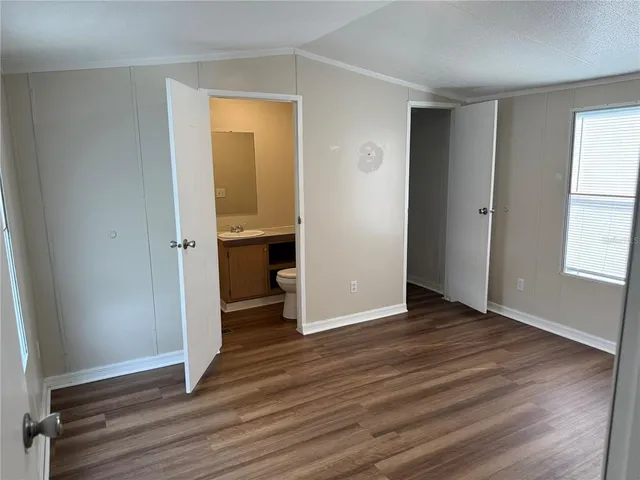 an empty room with wooden floor and a window