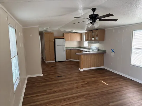 a view of a kitchen with a sink a ceiling fan and stainless steel appliances