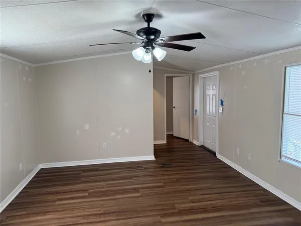 a view of empty room with wooden floor
