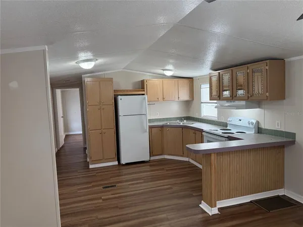 a kitchen with wooden floors and refrigerator