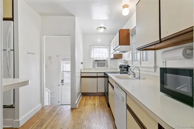 a kitchen with cabinets and wooden floor