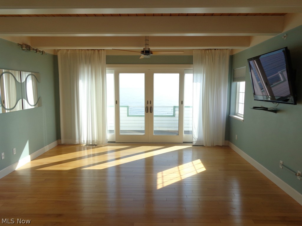 24 D Cedar Point Road Sandusky, OH 44870 - Photo 6 of 25 Living room w/Lake Erie views, maple hard wood flooring, the attached TV stays, patio door to the outside composite deck.