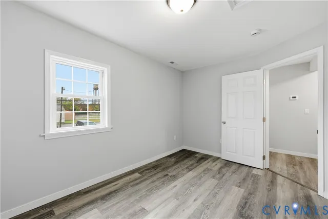 a view of a room that has wooden floor and window