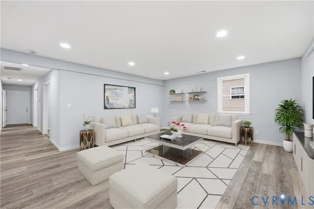 a living room with furniture and a wooden floor