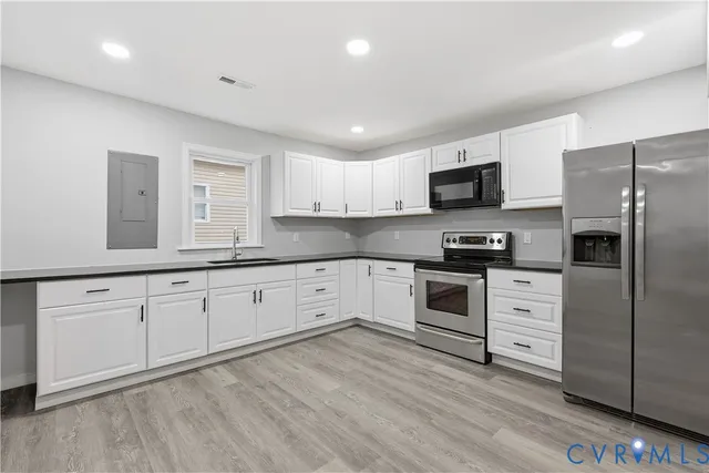 a kitchen with granite countertop white cabinets and stainless steel appliances