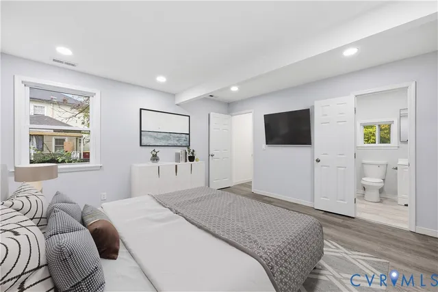 a bedroom with a bed tv and a window