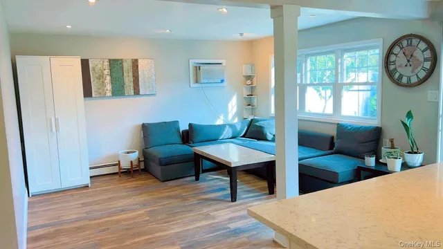 a living room with furniture a clock and a window