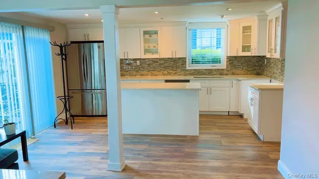 a kitchen with stainless steel appliances granite countertop a refrigerator a sink and a stove