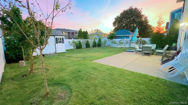 a view of a house with backyard and a tree
