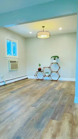 a room with wooden floor and chandelier