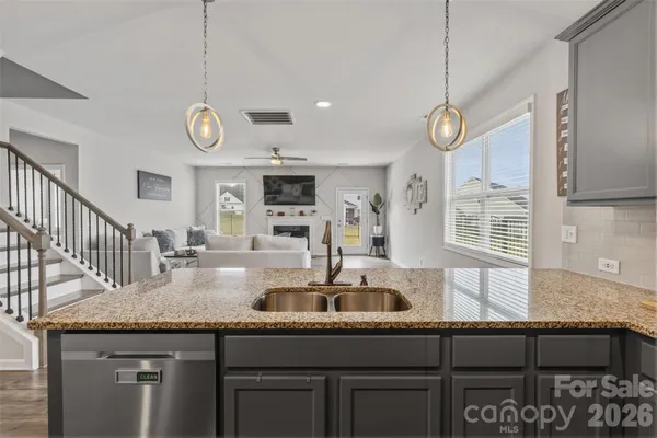 a kitchen with stainless steel appliances granite countertop a sink a oven and a wooden floors
