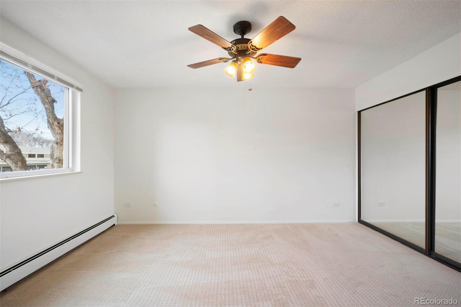 580 South Clinton Street, Unit 9B Denver, CO 80247 - Photo 11 of 30 an empty room with a window and a ceiling fan