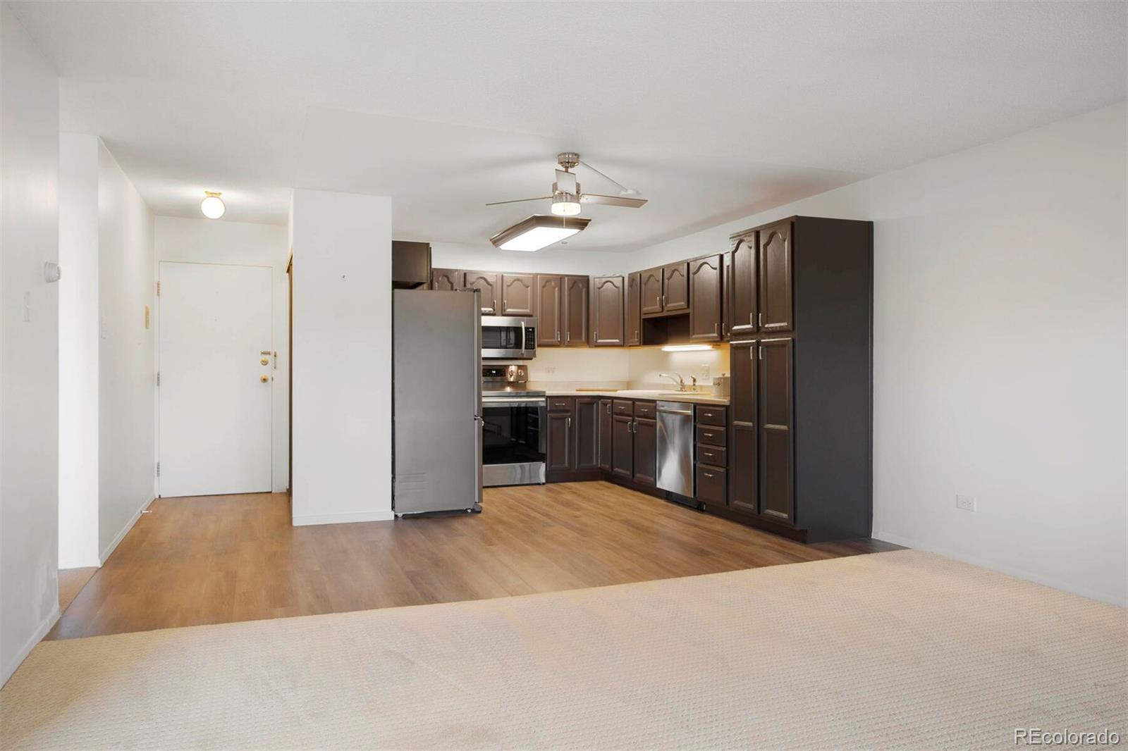 580 South Clinton Street, Unit 9B Denver, CO 80247 - Photo 6 of 30 a large kitchen with cabinets and stainless steel appliances
