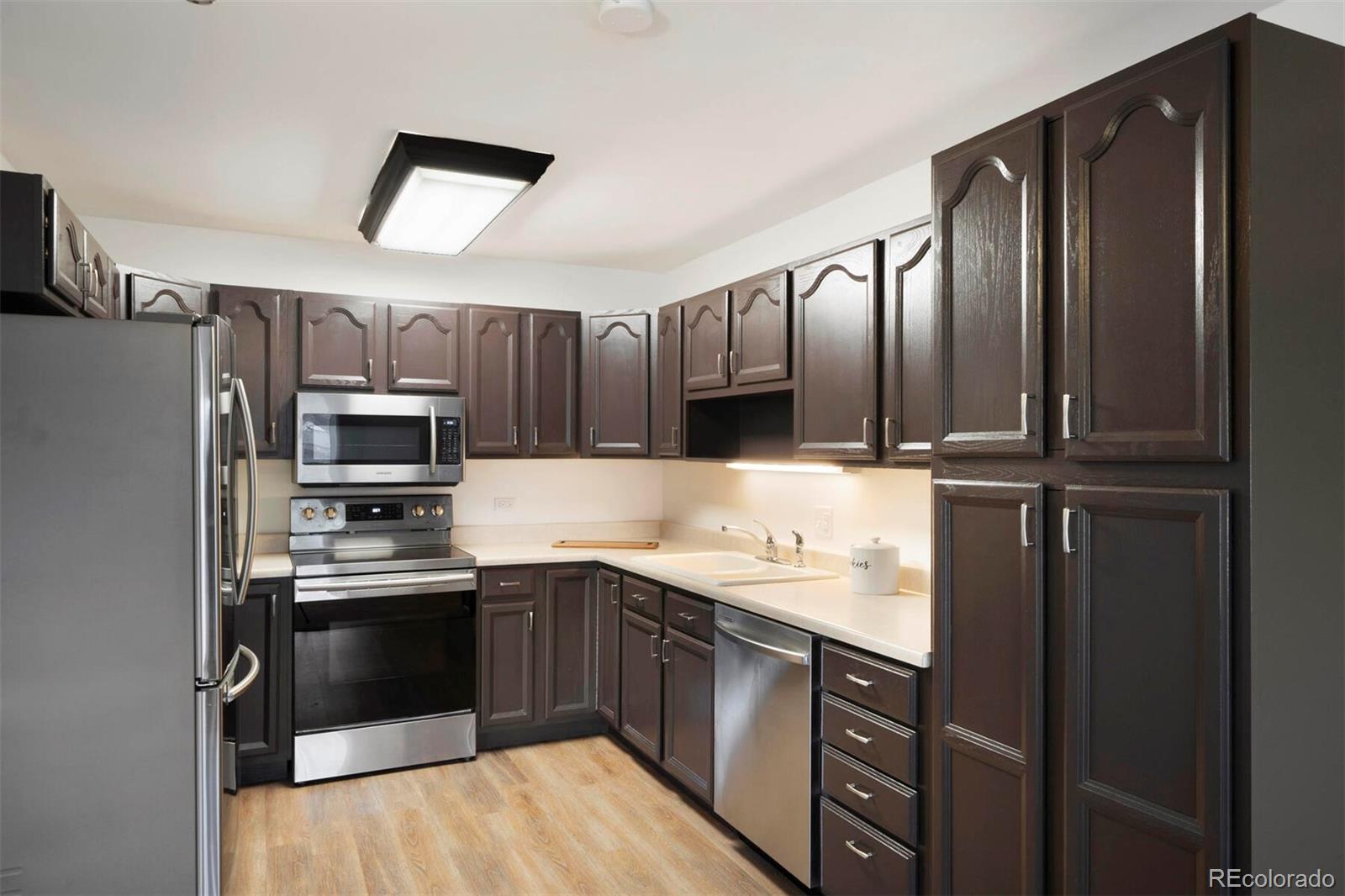 580 South Clinton Street, Unit 9B Denver, CO 80247 - Photo 7 of 30 a kitchen with stainless steel appliances kitchen island granite countertop a refrigerator stove and sink