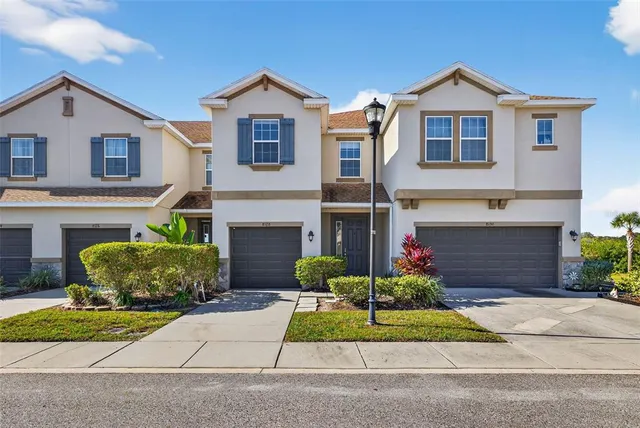 a front view of a house with a garden and plants