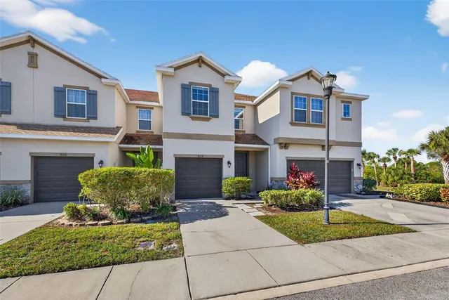 a front view of a house with a yard and potted plants
