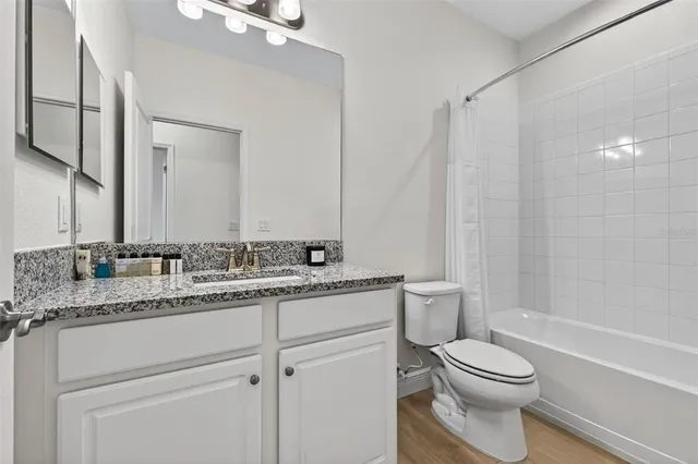 a bathroom with a granite countertop sink a toilet and a mirror