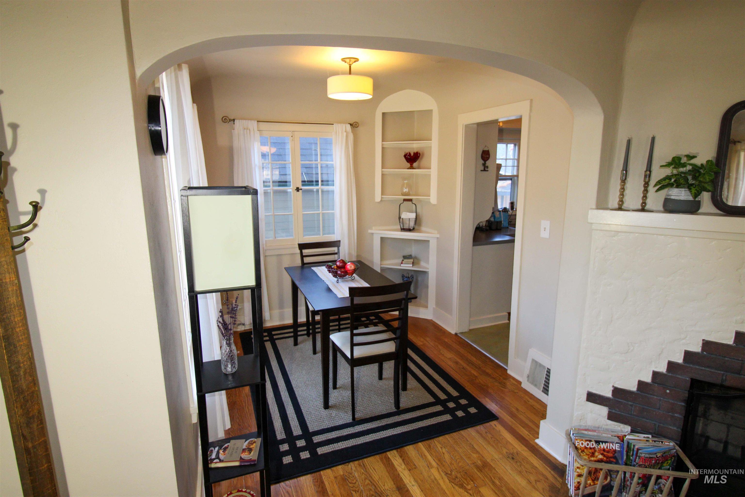 2551 West Hill Road Boise, ID 83702 - Photo 9 of 24 Dining area with wood finished floors, healthy amount of natural light, built in features, and arched walkways
