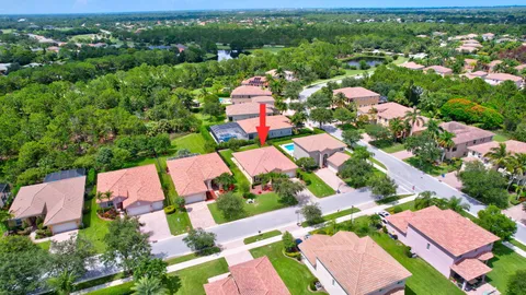 an aerial view of residential houses with outdoor space and trees all around