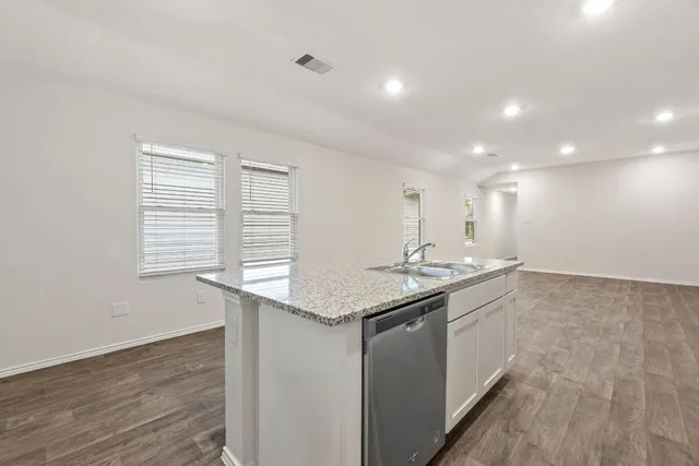 a kitchen with stainless steel appliances granite countertop a sink and dishwasher with wooden floor