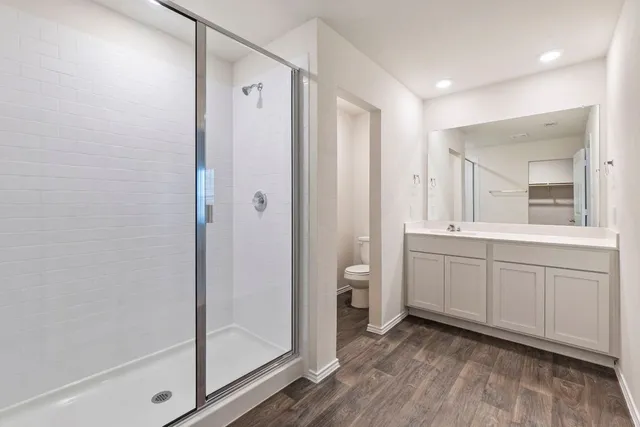 a spacious bathroom with a double vanity sink a mirror and a shower