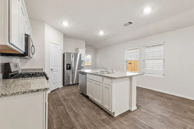 a kitchen with stainless steel appliances granite countertop a sink stove and refrigerator