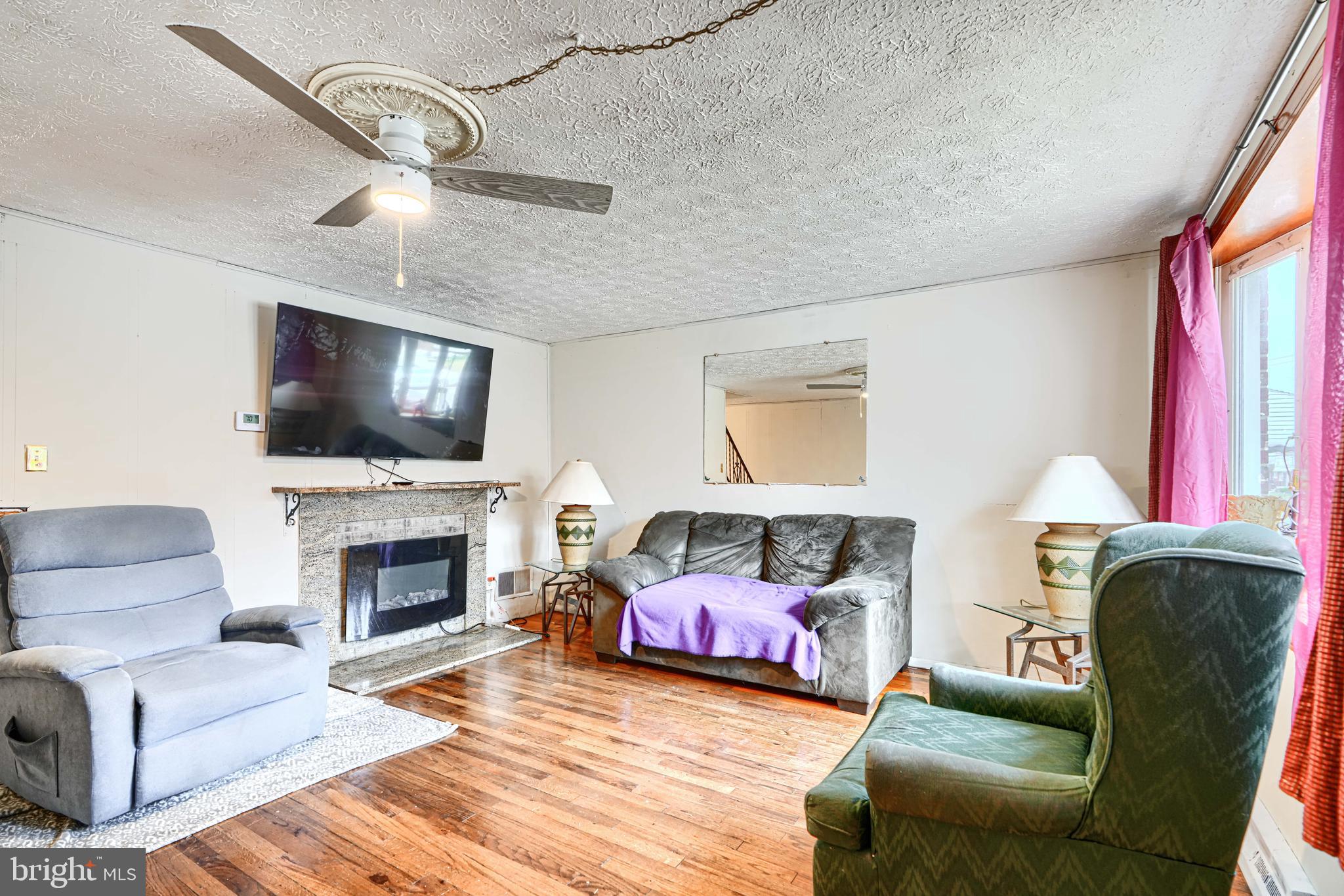 5552 Whitby Road Baltimore, MD 21206 - Photo 5 of 29 a living room with furniture a flat screen tv and a fireplace