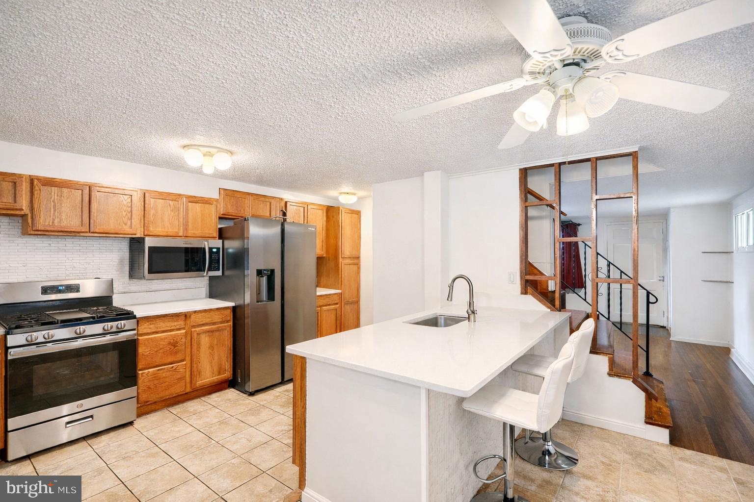 5552 Whitby Road Baltimore, MD 21206 - Photo 9 of 29 a kitchen with stainless steel appliances a stove a sink cabinets and a refrigerator